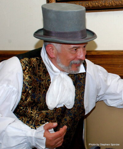 Tom Amesse in brocade vest and gray top hat.