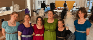 6 women in Regency gowns with feathers in their hair