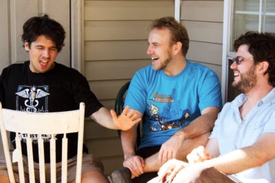 Three men sitting on a porch
