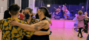 Dancers swing and the band on the stage.